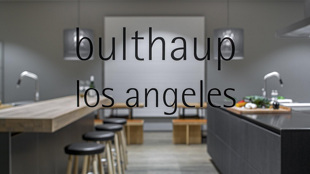 View through showroom window of kitchen island displays with bulthaup los angeles logo appearing.