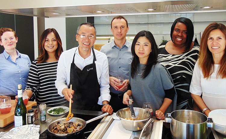 Group shot of Los Angeles team while they prepare a meal in b3 kitchen display.